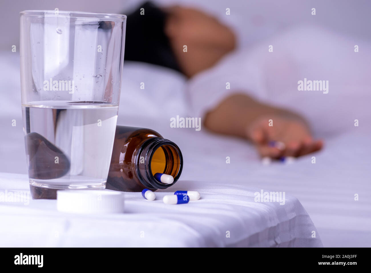 Woman lying on the bed after an overdose of pills at home. Overdose and suicide concept. Stock Photo