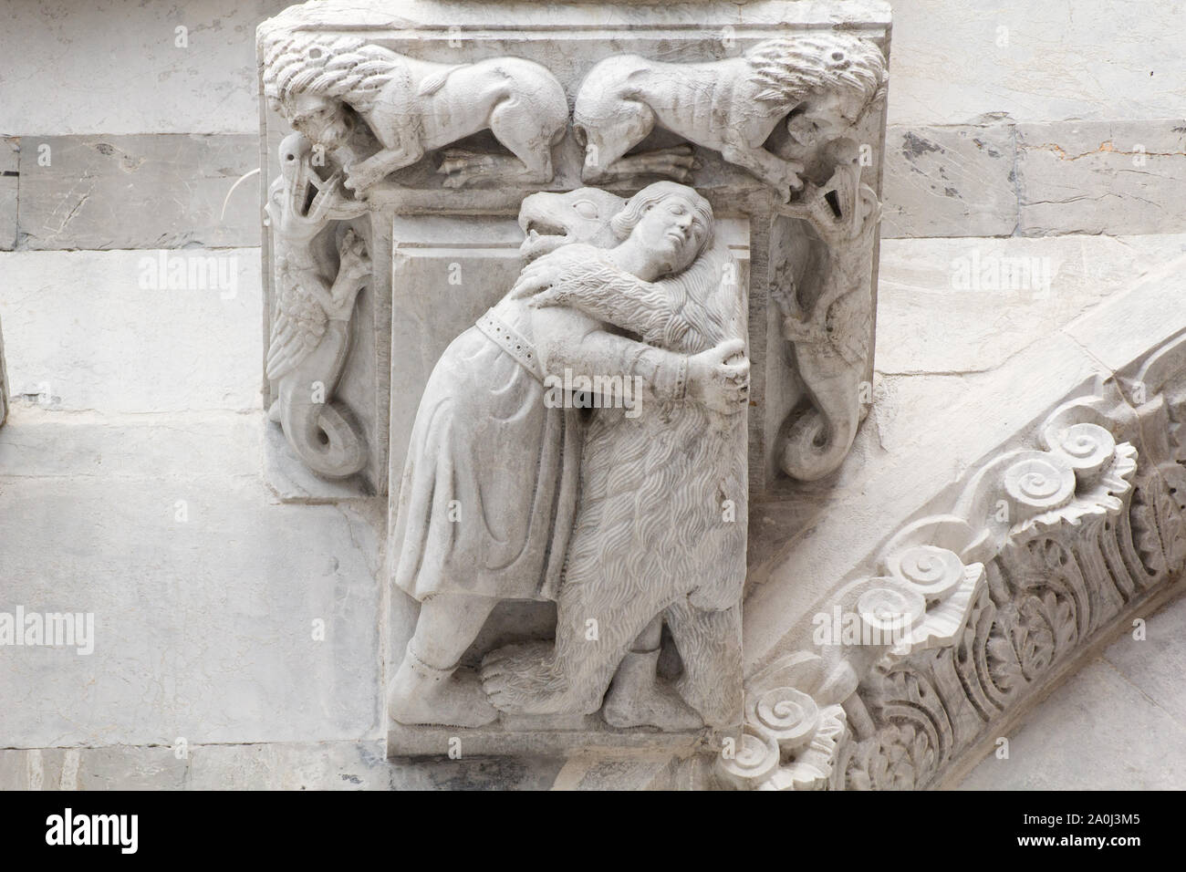 Medieval Imagery: A Bear embracing a Man (XIII C) - Romanesque façade of the Cathedral of Saint Martin in Lucca (Tuscany, Italy) Stock Photo