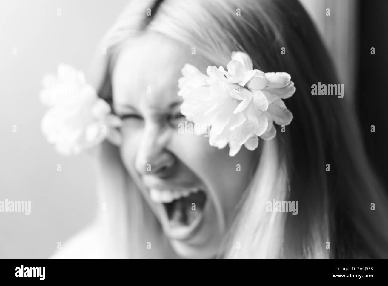 Blurred portrait of a young capricious girl screaming, female whim. Selective soft focus. Black and white Stock Photo