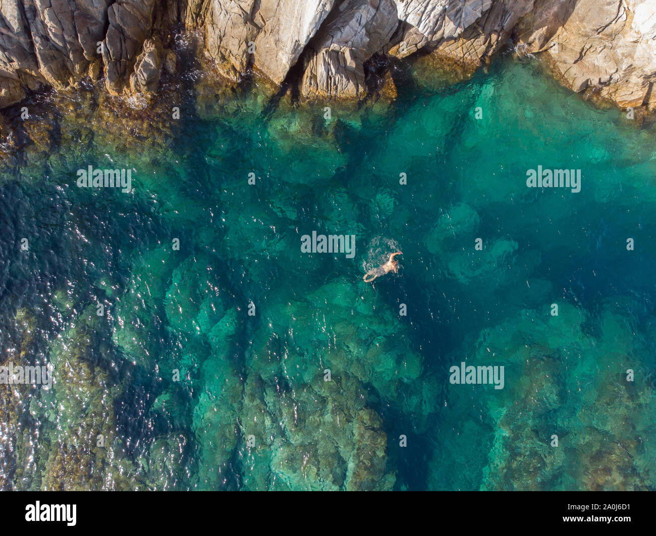 Birds eye view of a man swimming in a tropical lagoon. Stock Photo