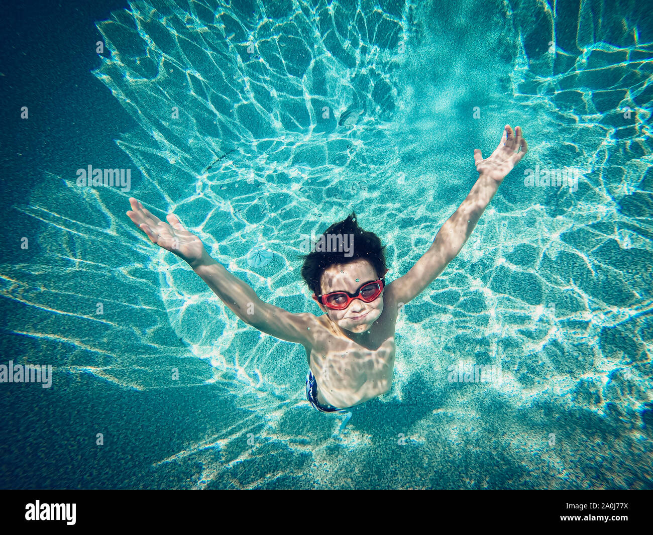 Underwater image of young boy floating in a swimming pool. Stock Photo