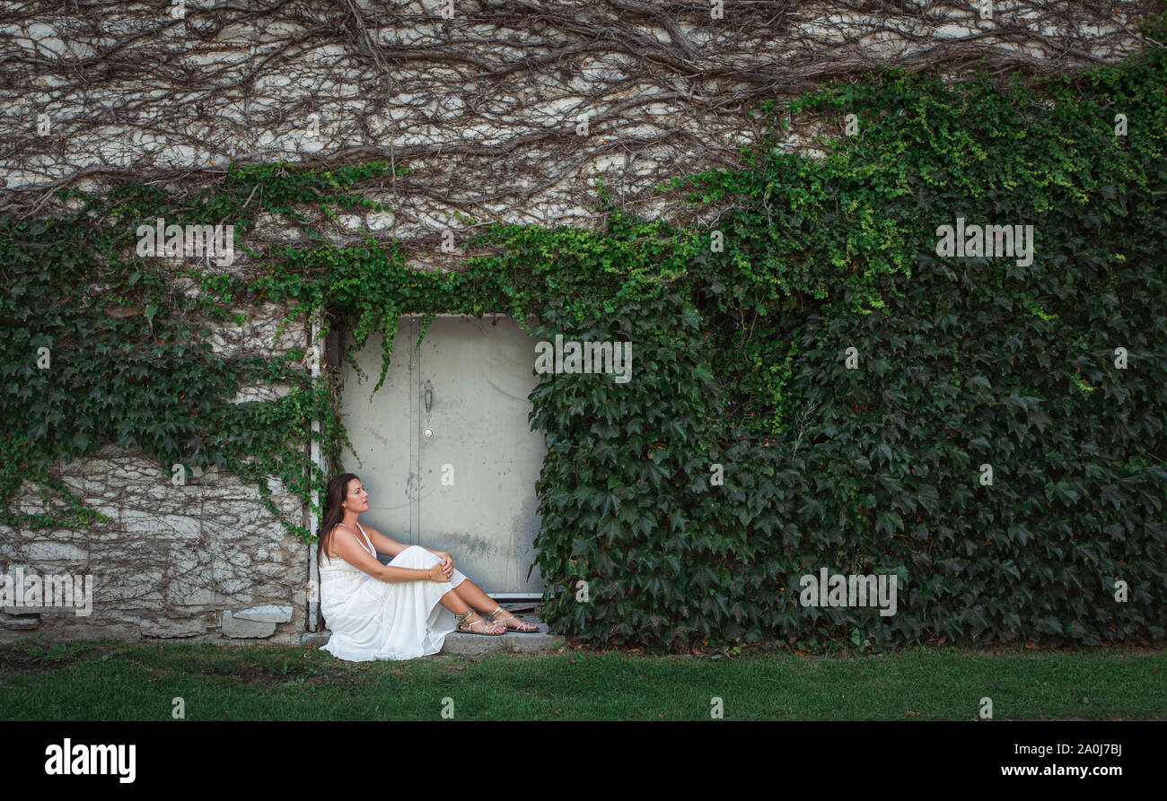 Woman sitting wall relaxed hi-res stock photography and images - Alamy