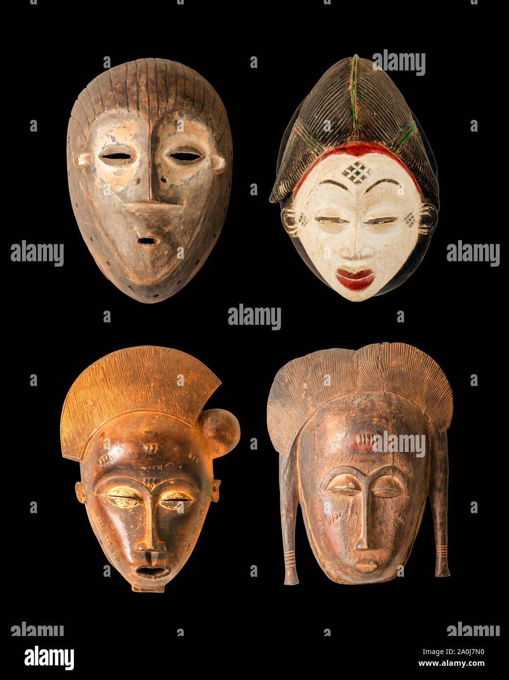 A collection of 4 African masks carved in wood isolated on black Stock