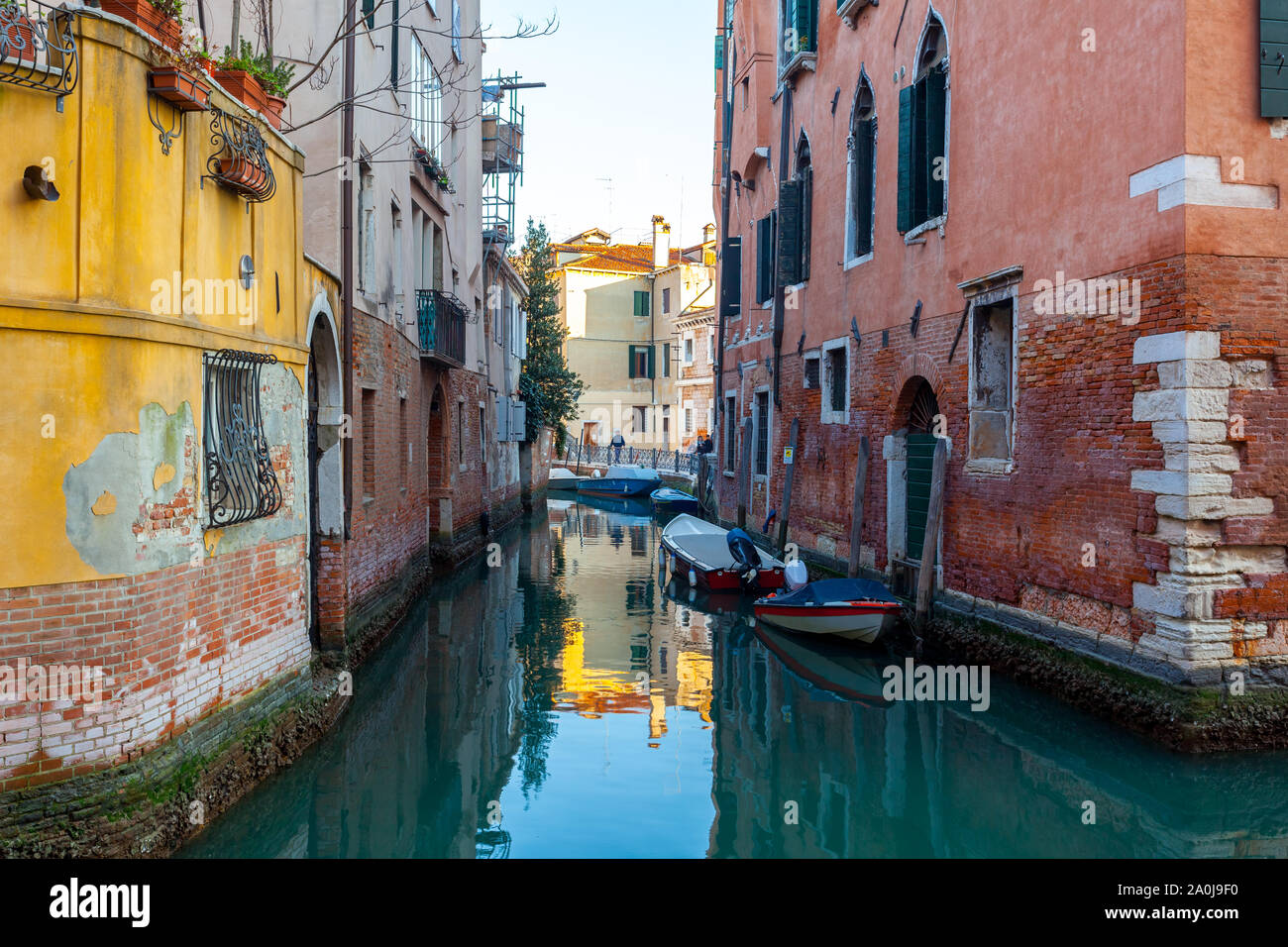 Boats on narrow canal between colorful historic houses in Venice ...