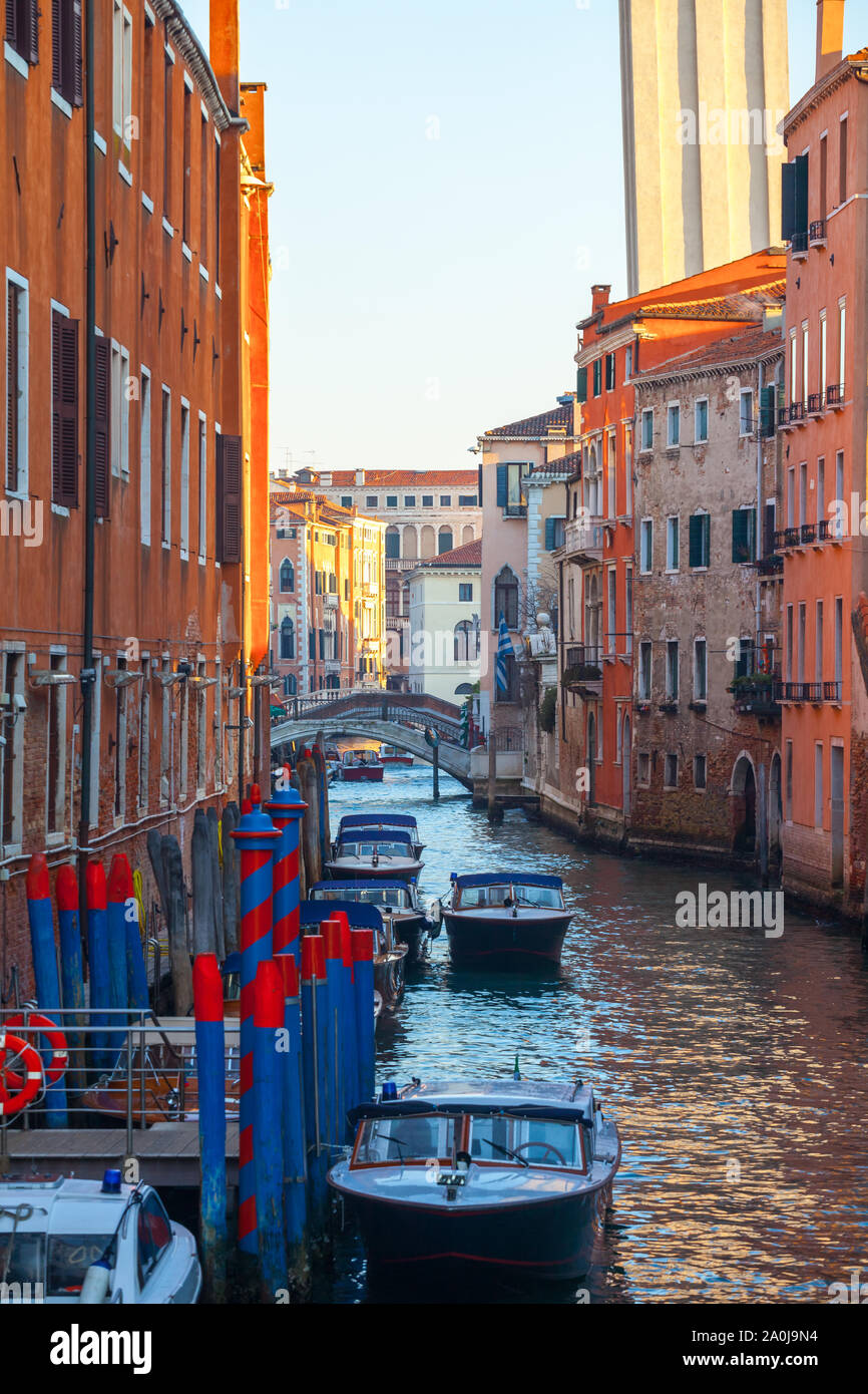 Boats on narrow canal between colorful historic houses in Venice ...