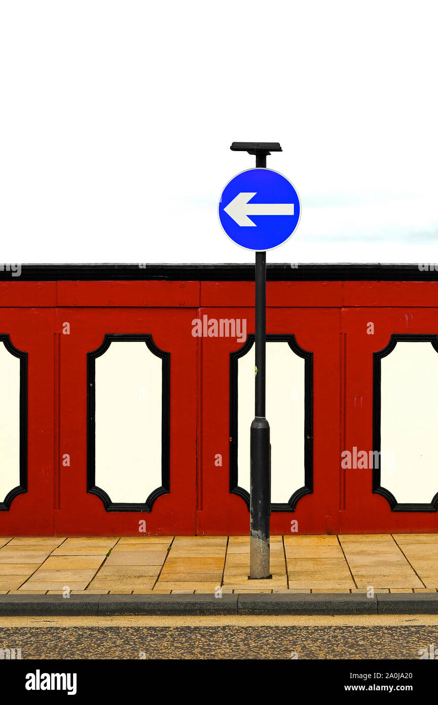 Blue traffic direction sign against red bridgework Stock Photo - Alamy