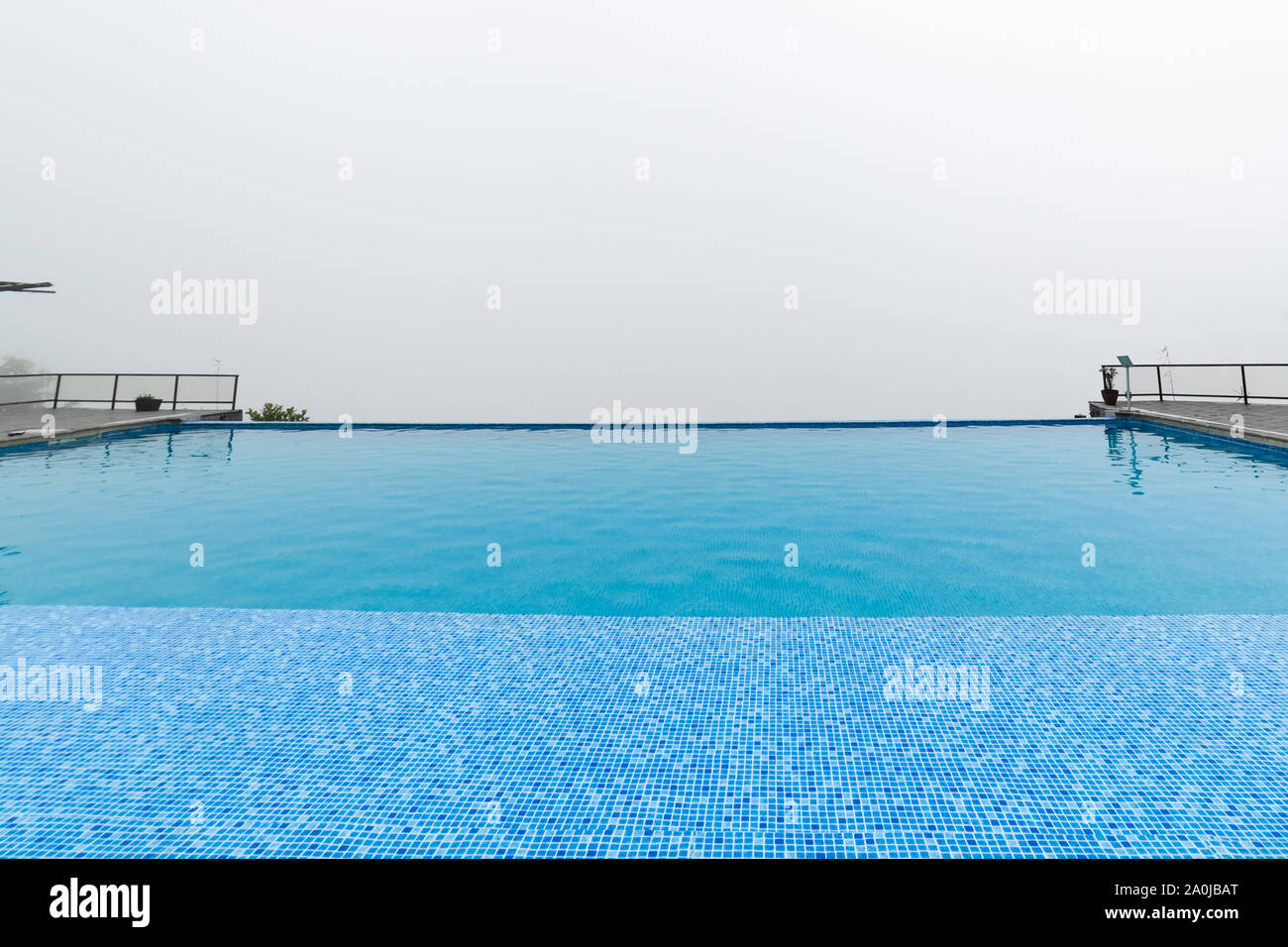 Infinity swimming pool with foggy white background Stock Photo Alamy