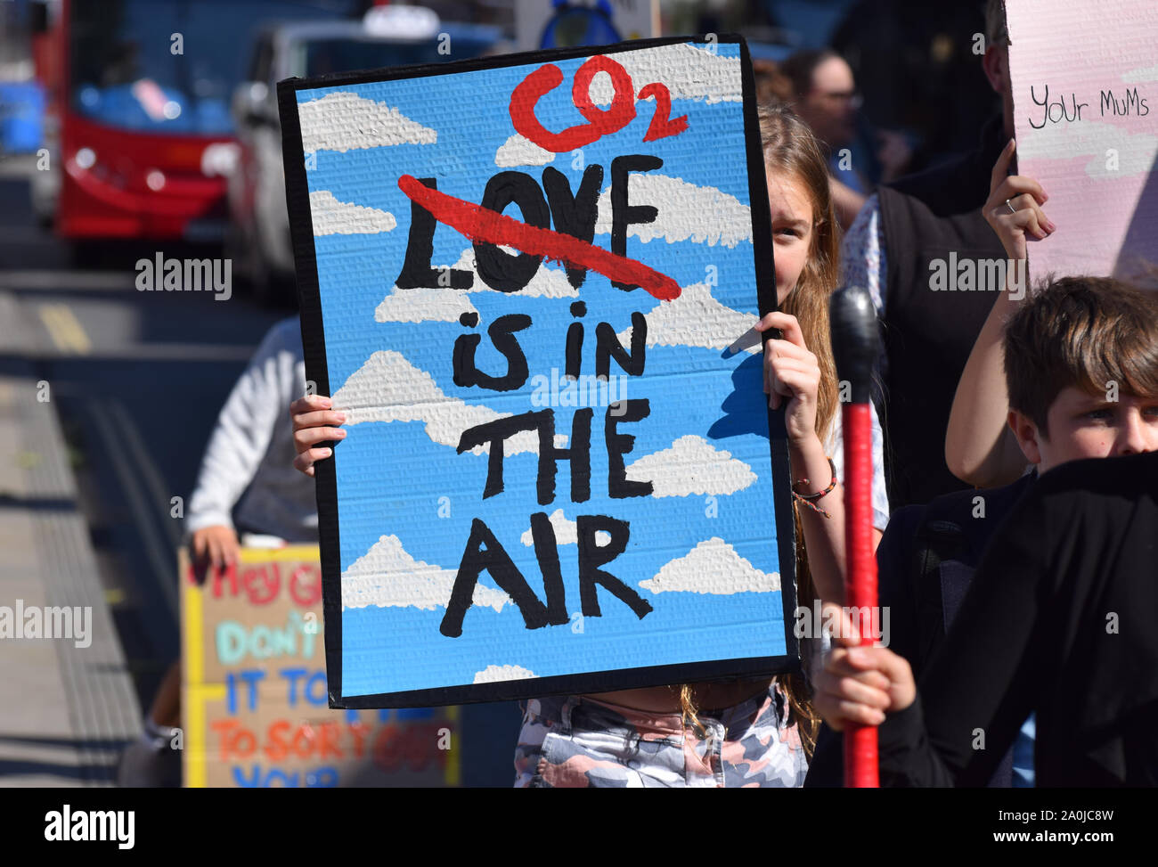 Young girl protesting against climat change in the UK holding a banner that reads 'CO2 is in the air' with the word 'love' crossed through Stock Photo