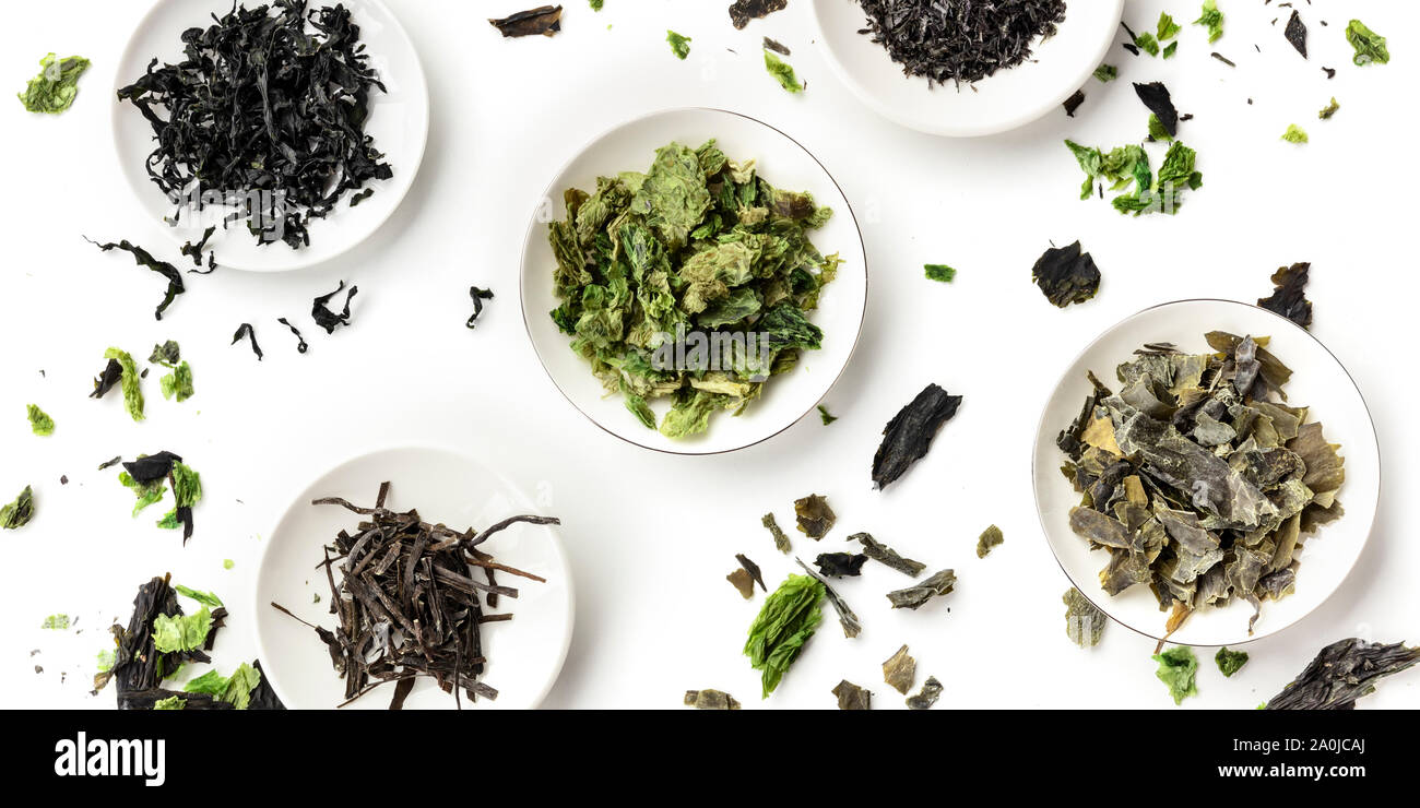 A panoramic overhead shot of a variety of dry seaweed, sea vegetables, on a white background Stock Photo