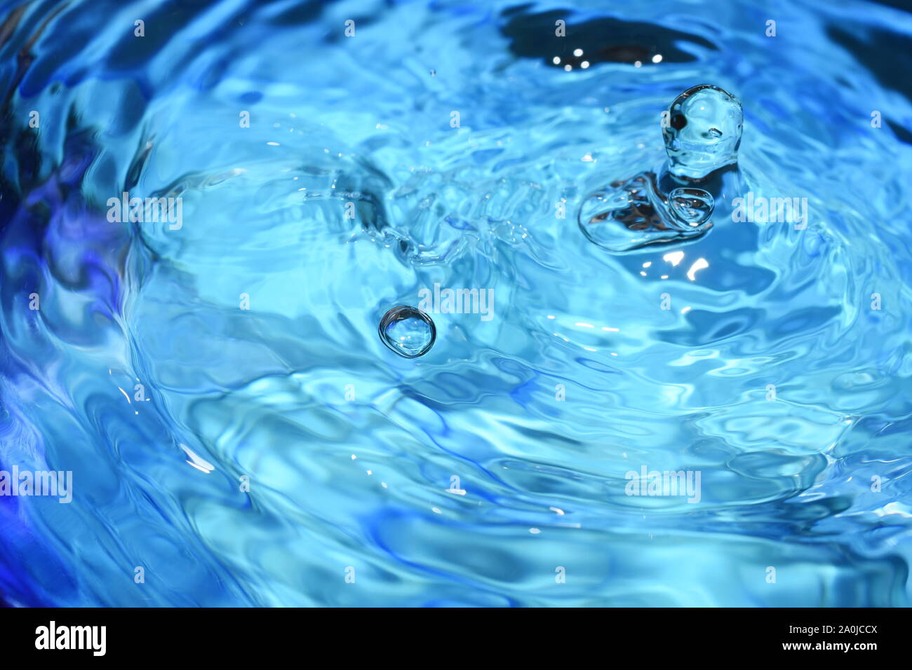 Splash and ripples in blue water liquid Stock Photo Alamy