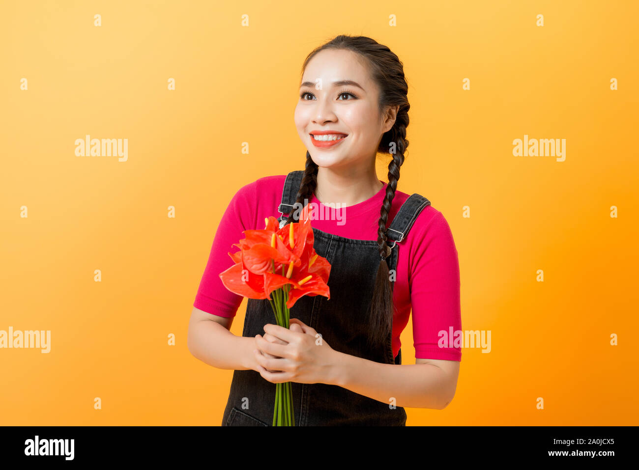 Beauty woman Asian cute girl feel happy holding bouquet of flowers on yellow background Stock Photo