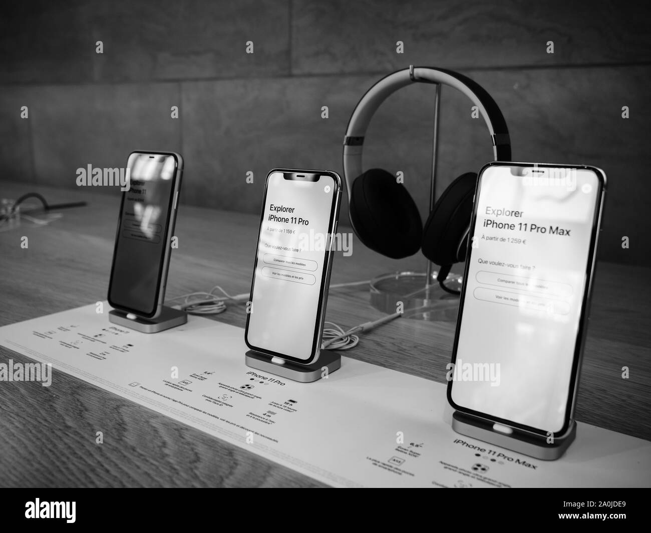 Paris, France - Sep 20, 2019: The new iPhone 11, 11 Pro and Pro Max range displayed in Apple Store next to Beats by Dr Dre Headphones black and white image Stock Photo