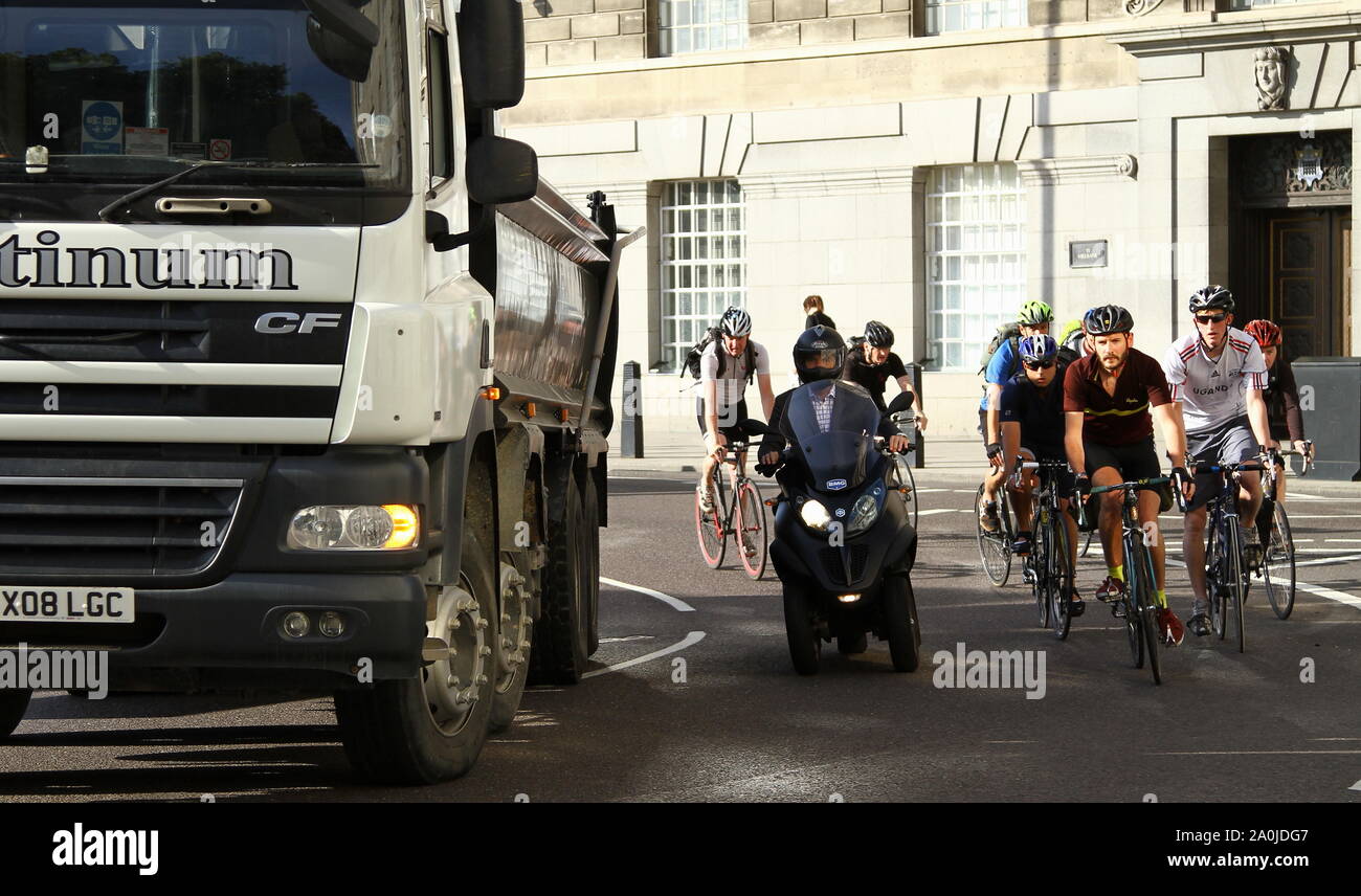 CYCLISTS COMMUTE TO WORK ON LONDON'S MILLBANK WHERE SERIOUS ACCIDENTS HAVE OCCURED . HERE THIS PHOTOGRAPH SHOWS ORDERLY LANE DISCIPLINE. HOWEVER THERE ARE BLIND SPOTS TO A LARGE VEHICLE REAR VIEW MIRRORS WHEN SMALLER ROAD USERS GET CLOSE. DRIVERS OF LORRIES AND OTHER LARGE VEHICLES HAVE TO GO WIDE TO GET AROUND CORNERS AND CYCLISTS IN PARTICULAR TRY TO NIP PAST AN EVER CLOSING SPACE EVEN WHEN THE INDICATORS OF THE LARGE VEHICLES ARE OPERATING. TAKING CHANCES ON THE ROADS OF THE UNITED KINGDOM, IS IT WORTH IT ? DRIVE AND RIDE SAFELY. ROAD SAFETY. Stock Photo