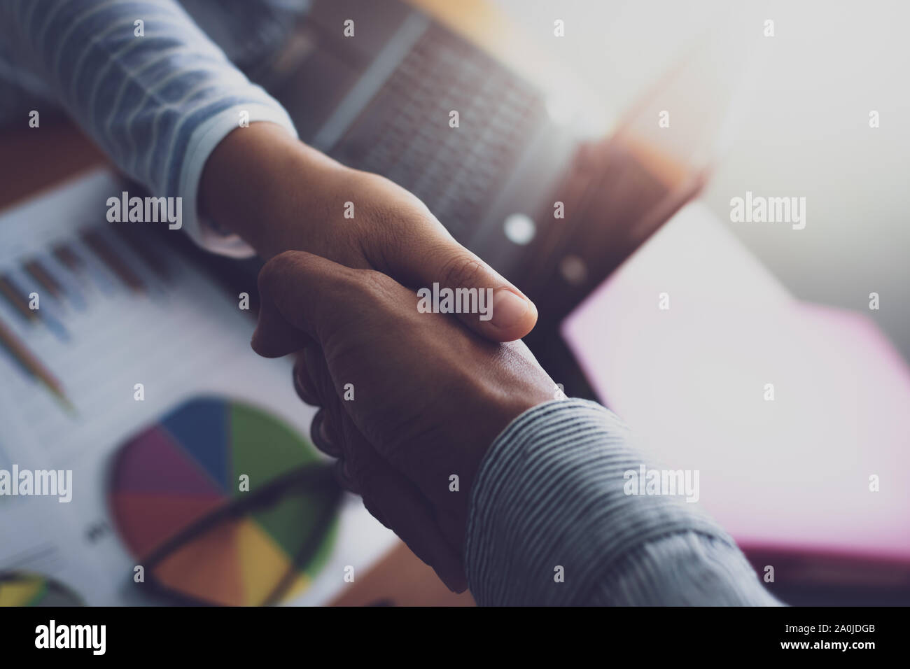 Two colleagues shaking hands together celebrating finished work. Business concept. Stock Photo