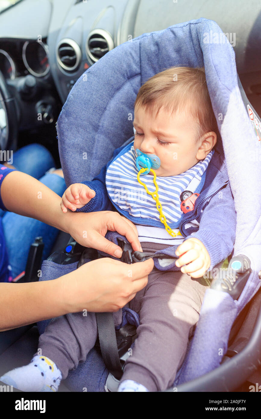 children car chair. baby car seat for safety. Protection in the car. Mother and child boy in car. Safety driving concept - woman is fastening security Stock Photo