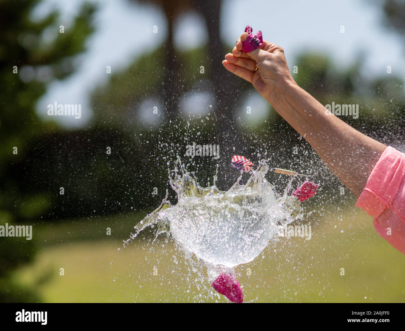 Sequence in several photos of the launch of a dart against a water ...