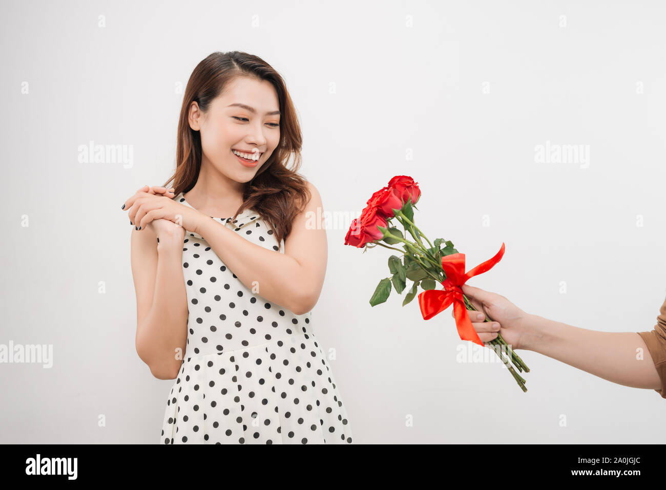 Cheerful charming young woman receiving bunch of flowers from her