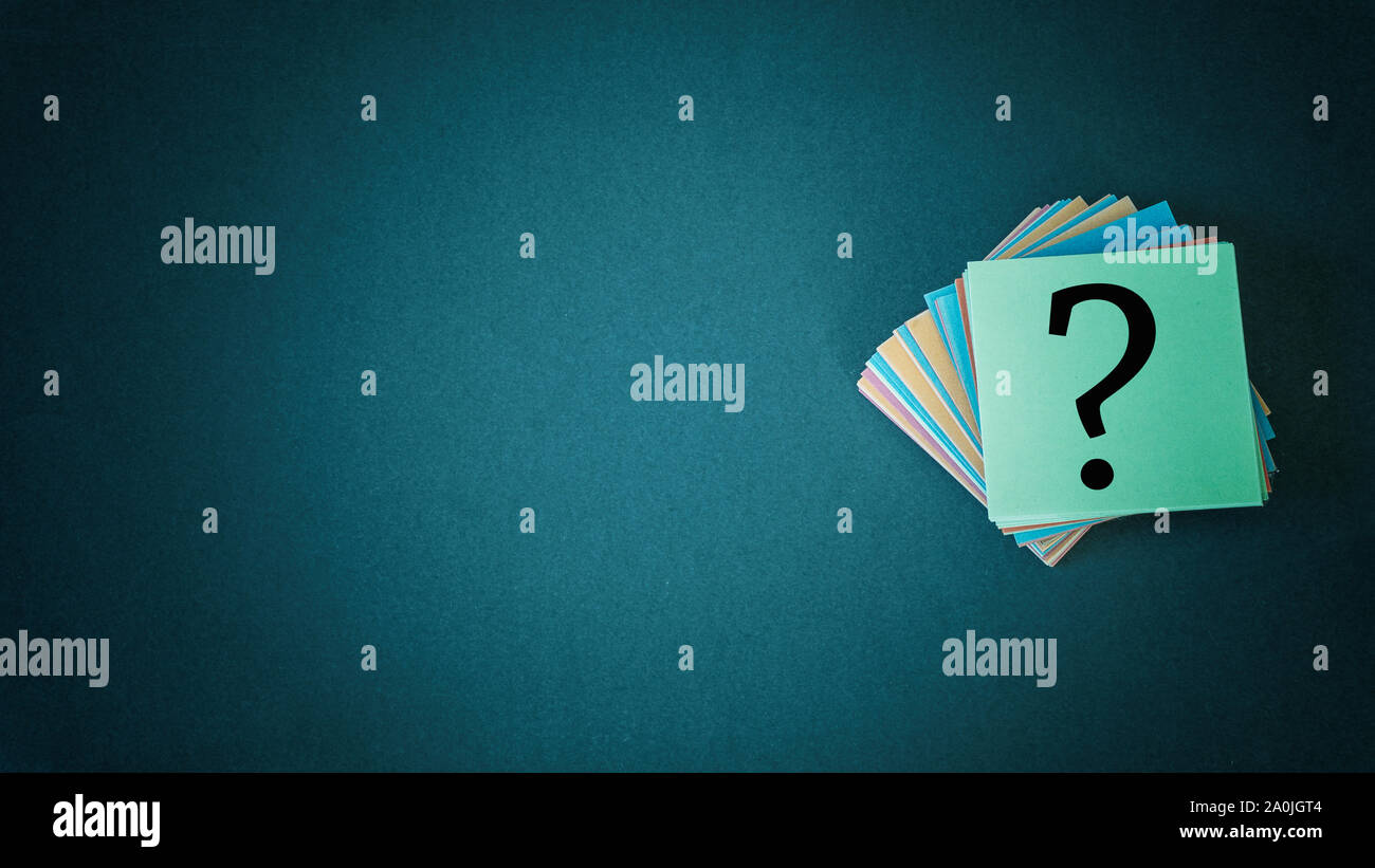 Stack of colorful papers with question marks on black background copy space Stock Photo
