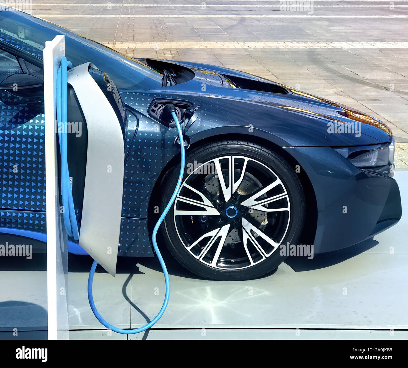 Electric vehicle being plugged in Stock Photo - Alamy