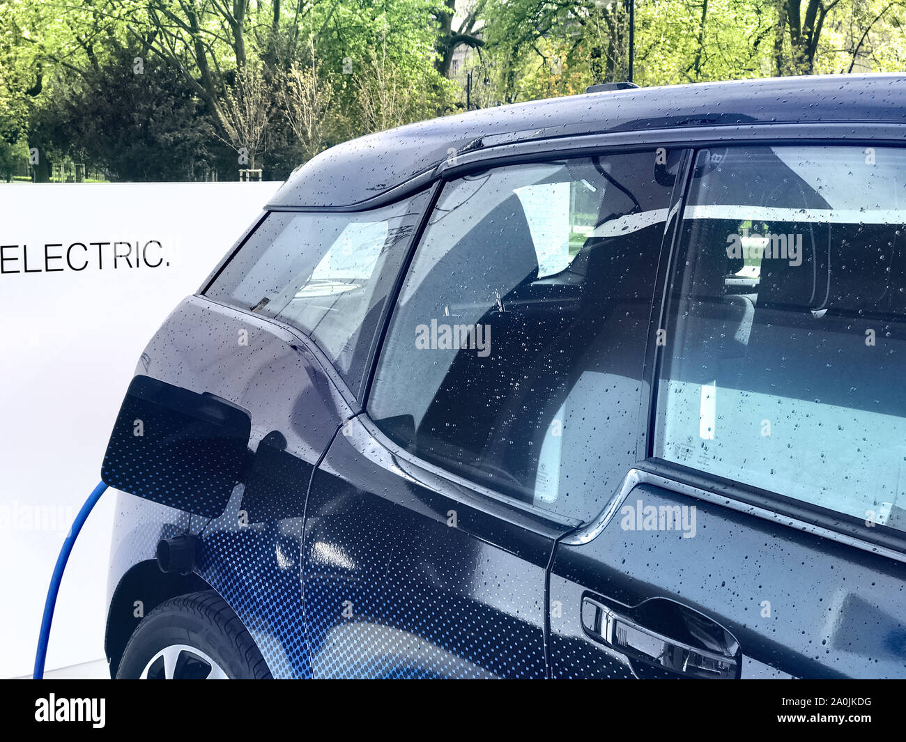 Electric vehicle being plugged in Stock Photo - Alamy