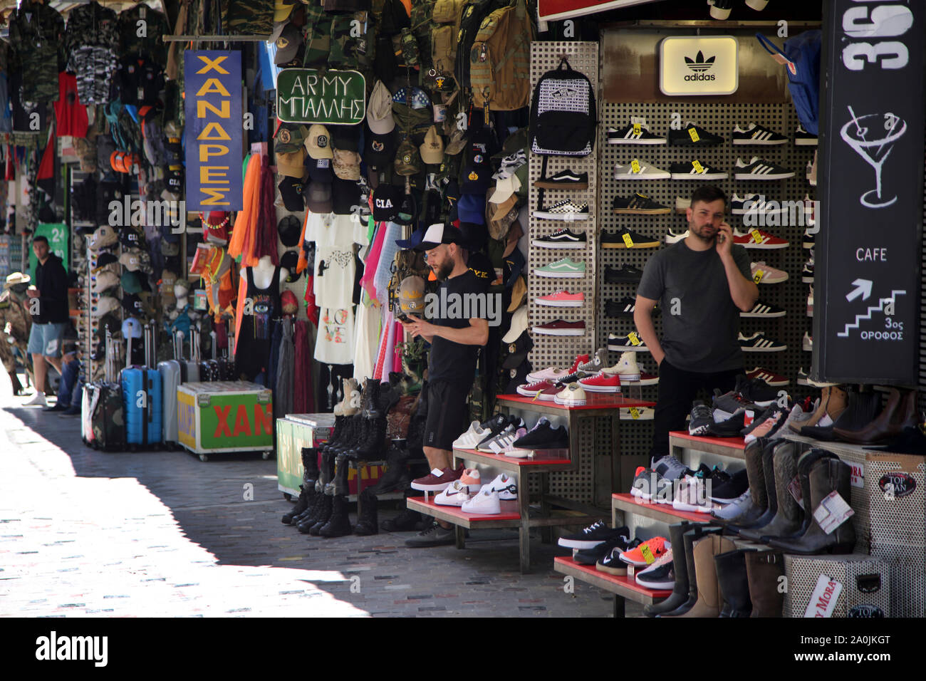 monasteraki athens Greece Bazaar Flea Market Shoes on sale Men using  Smartphones Stock Photo - Alamy
