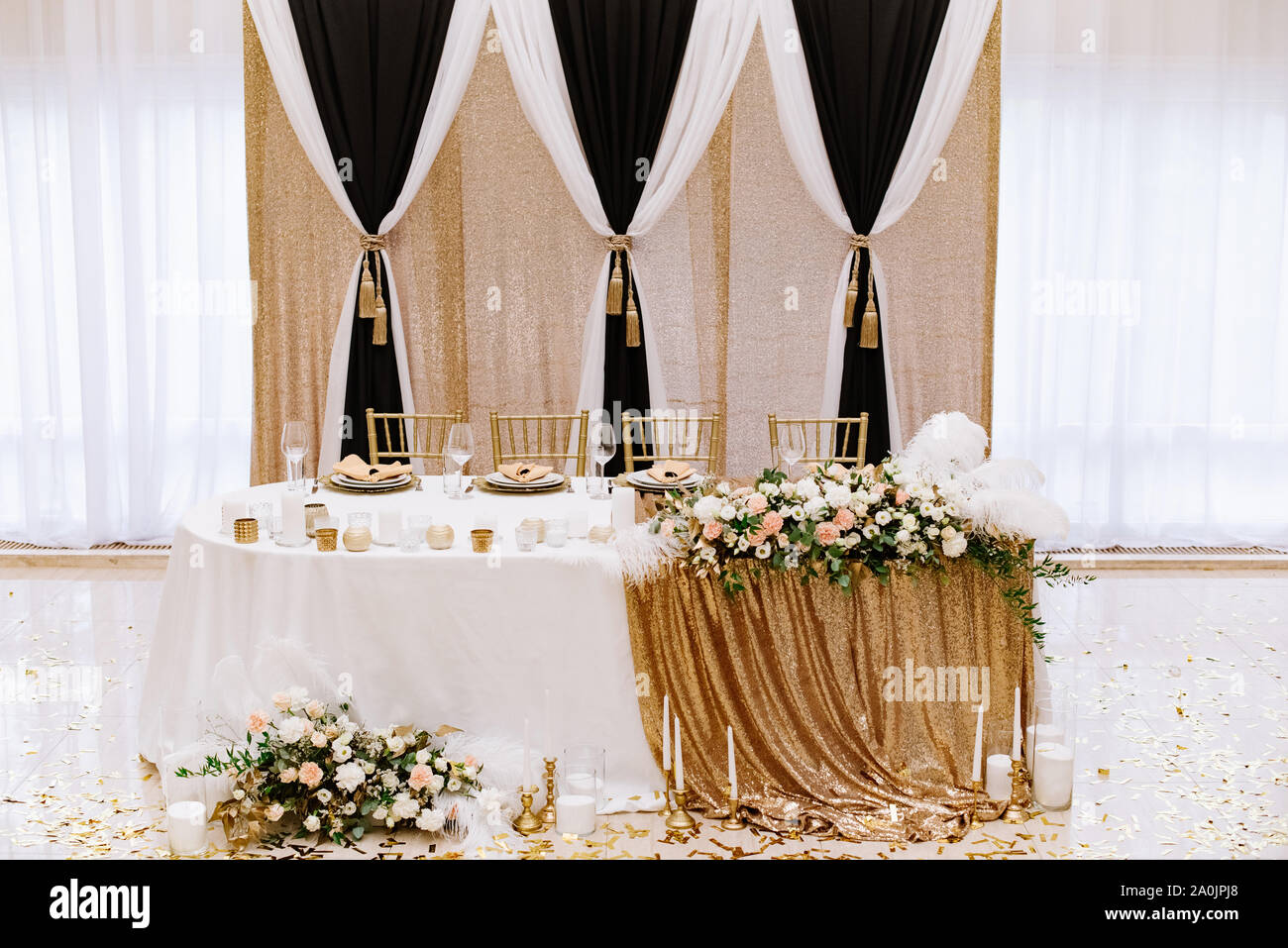 Compact stylish wedding presidium on a luxurious background in the white hall of the restaurant Stock Photo