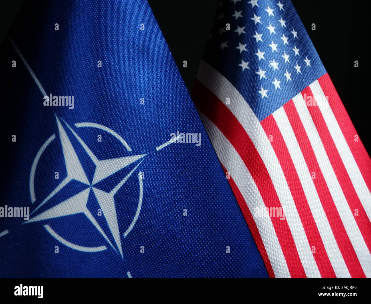 NATO and USA flags in dark. Stock Photo