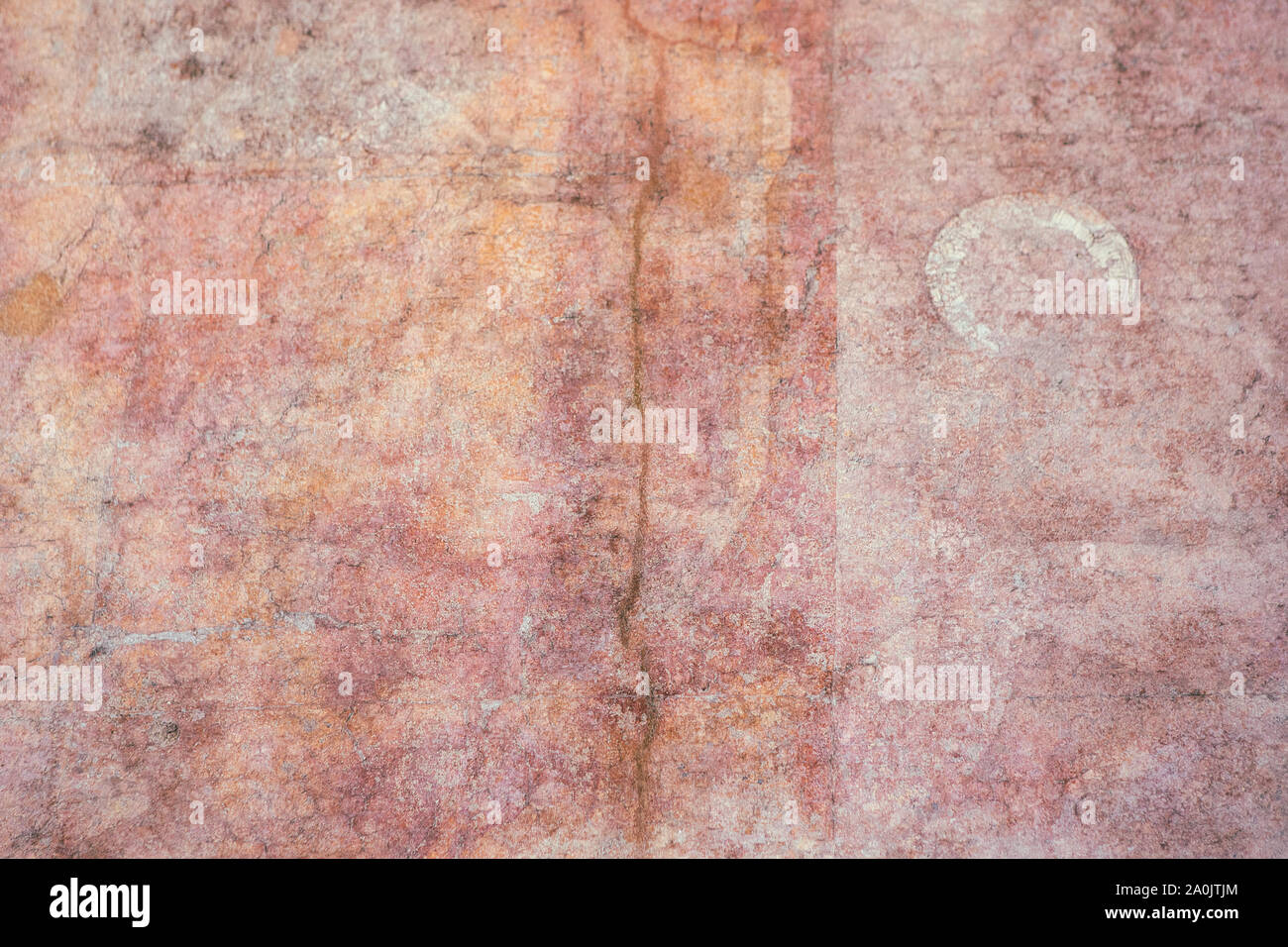 Antique, medieval pink plaster wall surface. Very old colorful wall texture with a crack. Abstract pink orange background. Stock Photo