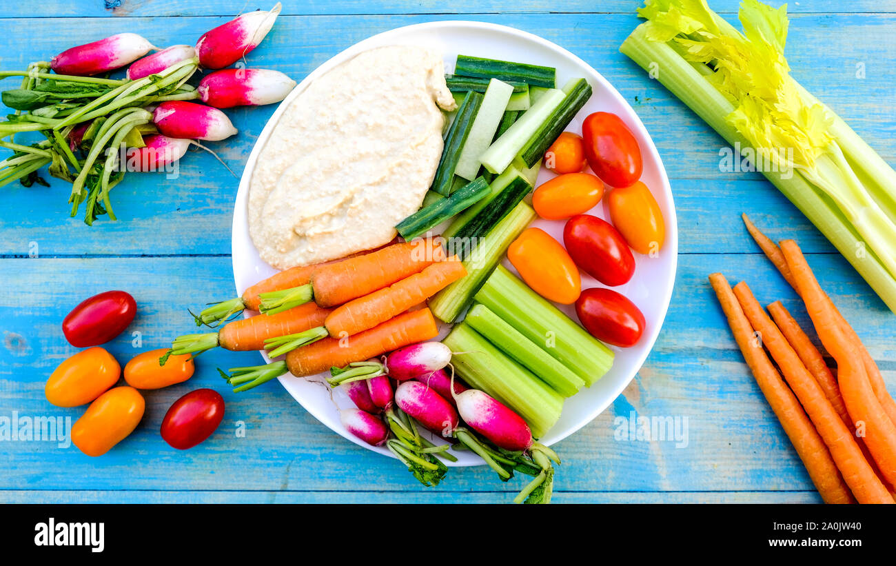 Fresh Vegetable Crudite Platter With Hummus and Baby Carrots, Radishes, Cucumber, Celery and Tomatoes Stock Photo