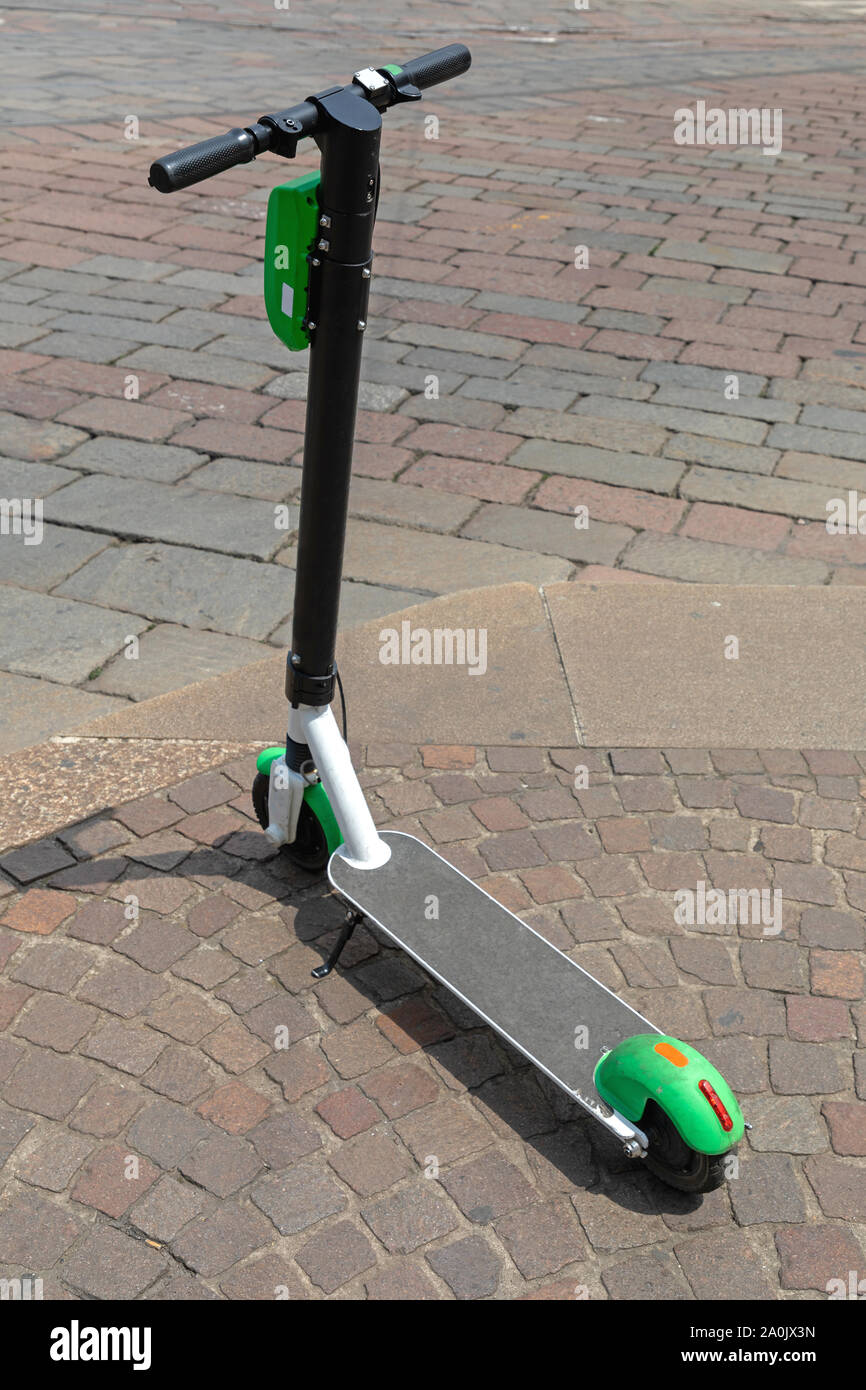 Electric Scooter for Rent Parked at Pavement in City Stock Photo