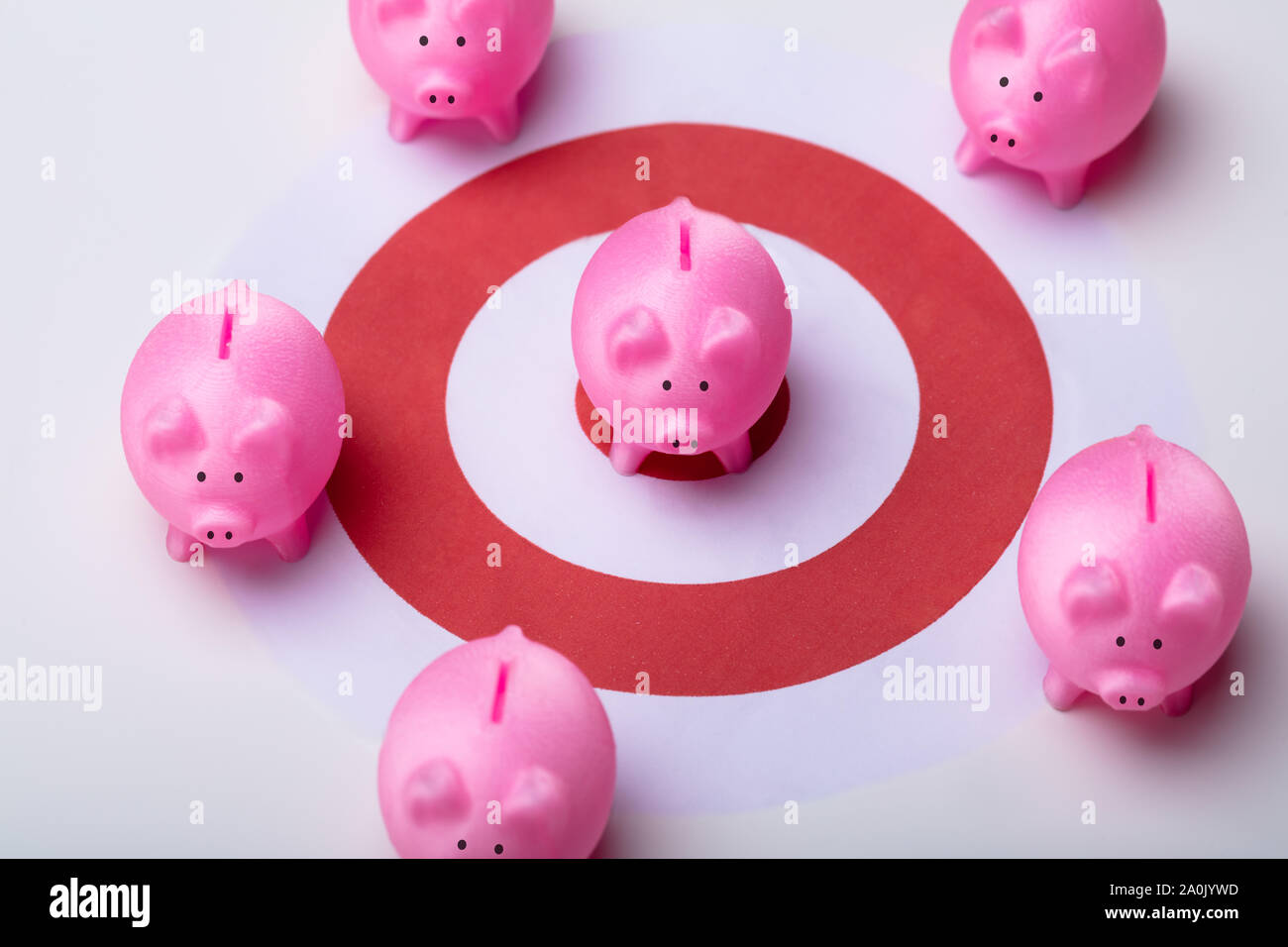 Pink Piggy Banks On Darts Target Surrounded With Other Piggy Banks Over