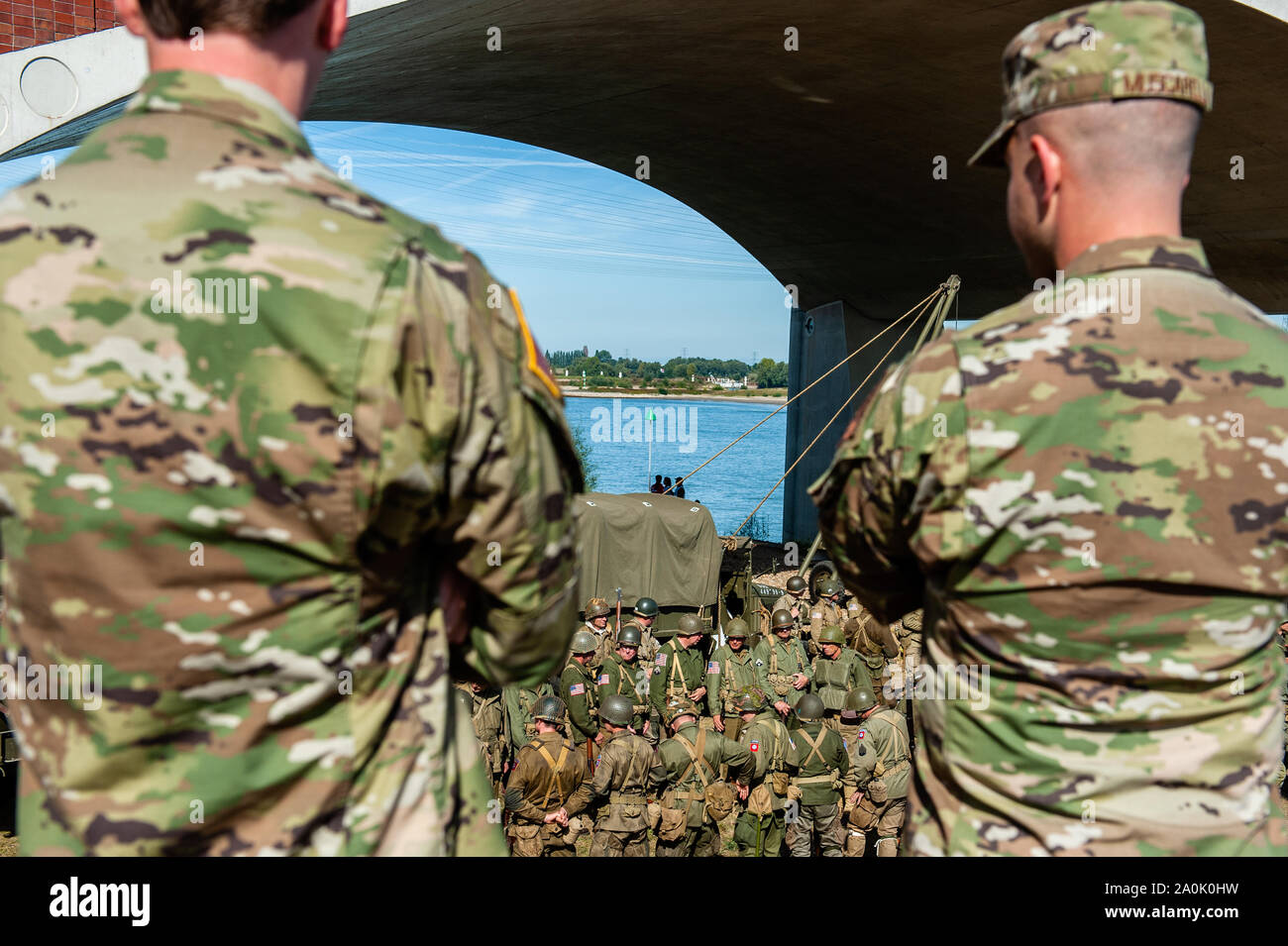 Two soldiers watch the recreation.On this day in 1944, 260 men of the 82nd Airborne Division went paddling to the other side of the Waal River. They reached the other side under heavy fire and managed to break through the German defence. However, half of them were injured or killed. Exactly 75 years later, 'Pontoon Group '40 -'45', in collaboration with Vereniging MARS and various other re-enactment associations, commemorated the  Waal crossing by paddling in the Waal river at the same exact locations. This event also belongs to the Commemorations of the 75 anniversary of Operation Market Gard Stock Photo