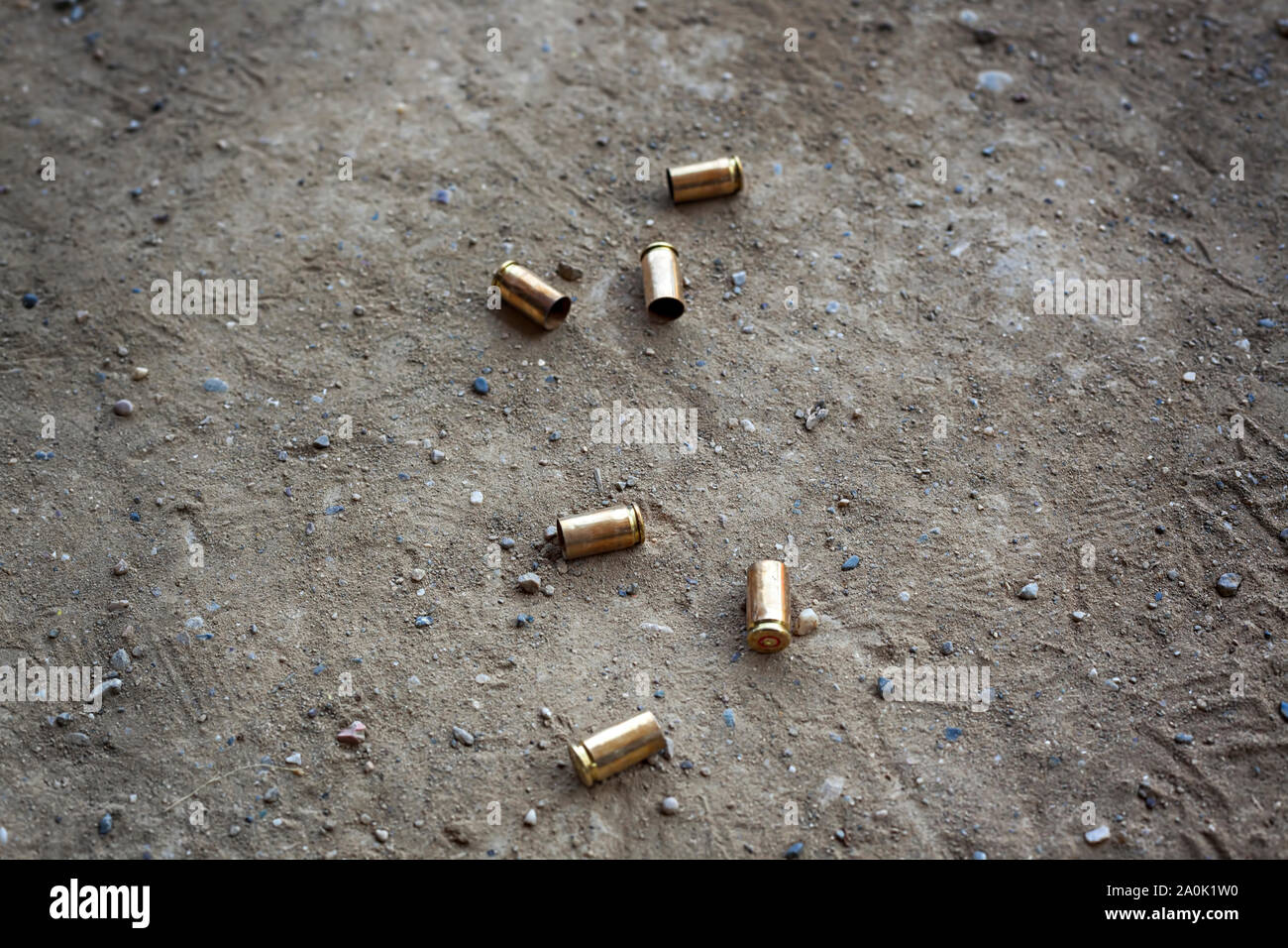 9 mm empty bullet shells lying on desert dirt with some rocks Stock