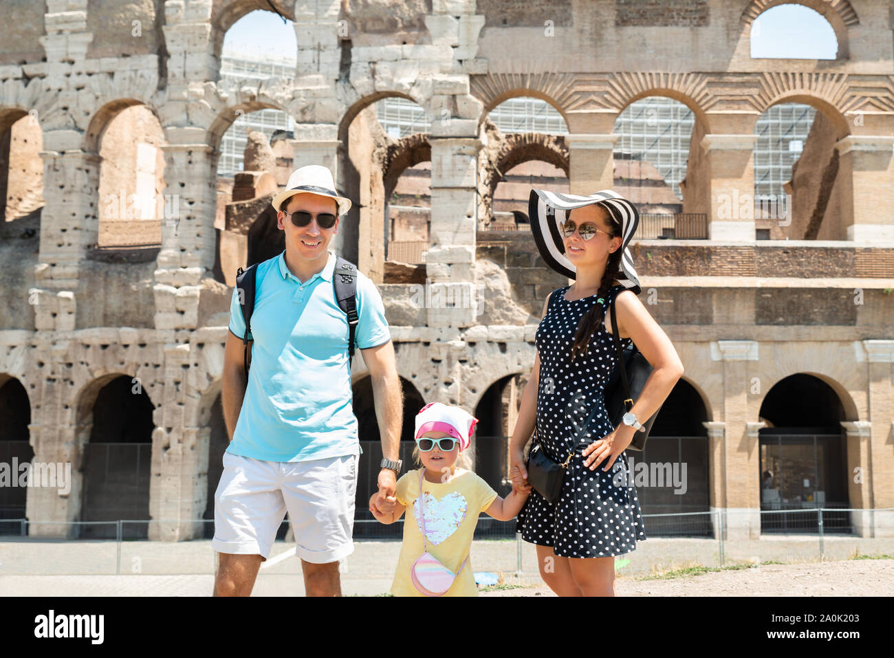 Young Tourist Family Standing In Front Of Colosseum In Rome, Italy Stock Photo