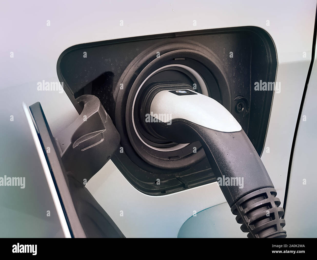 Electric vehicle being plugged in Stock Photo - Alamy