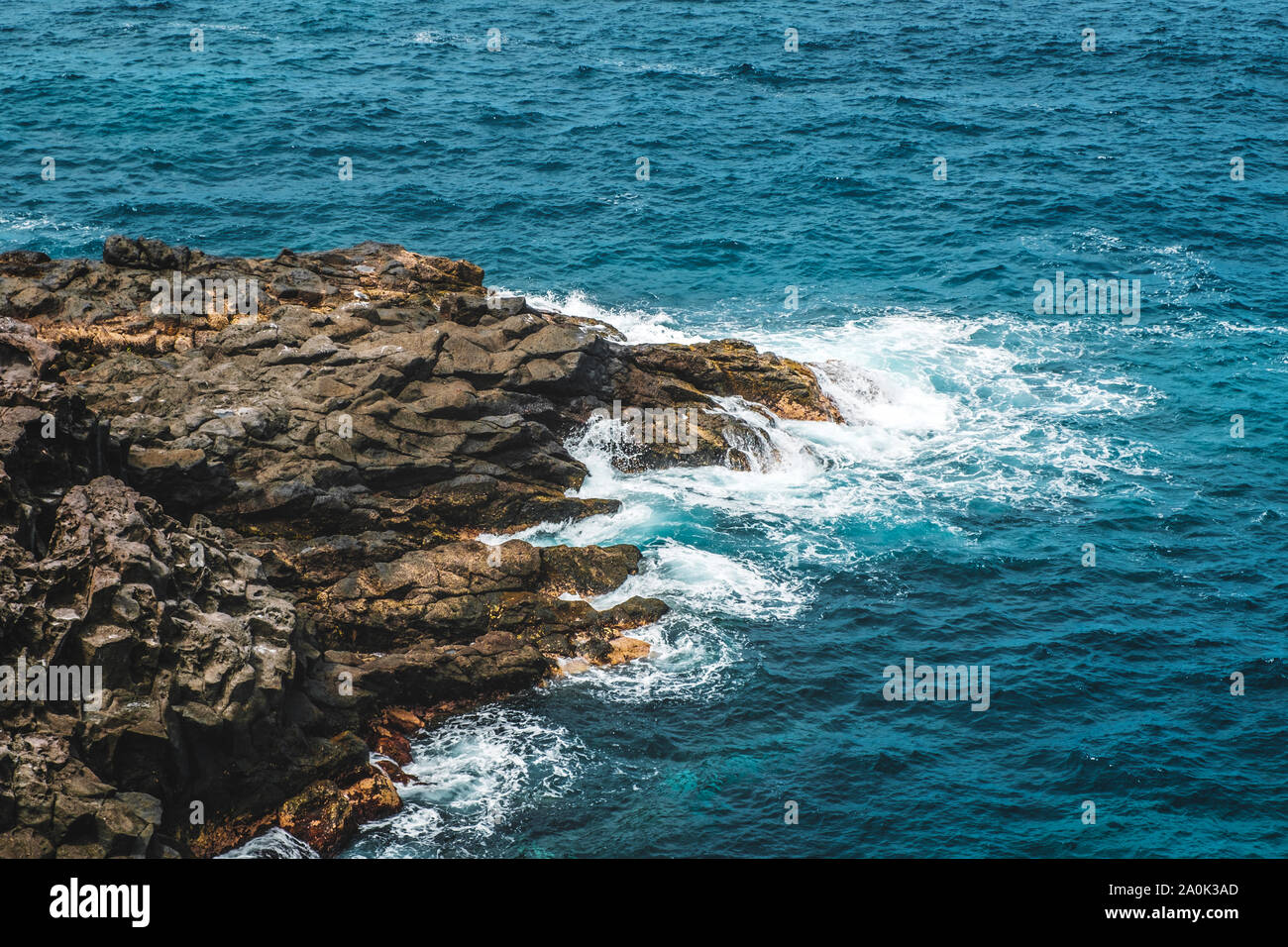 rocky coast, waves hit rock at ocean shore Stock Photo