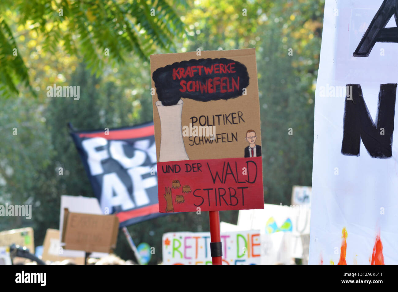 Demonstration during Global Climate Strike with cardboard banner saying in German 'Power stations fumigate, politician ramble and the woods are dying' Stock Photo