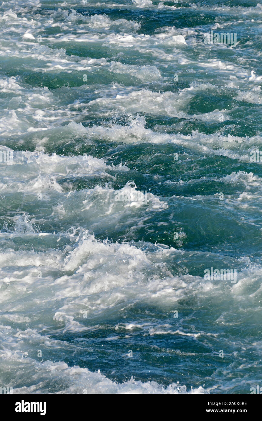 A vertical image of ocean water being displaced by a boat traveling