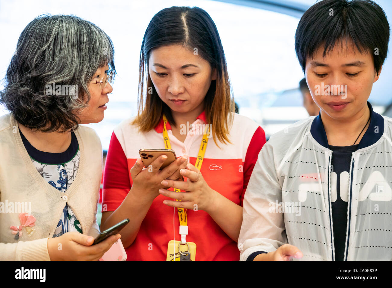Customers look at Apple's new iPhone 11 series smartphones at an Apple ...