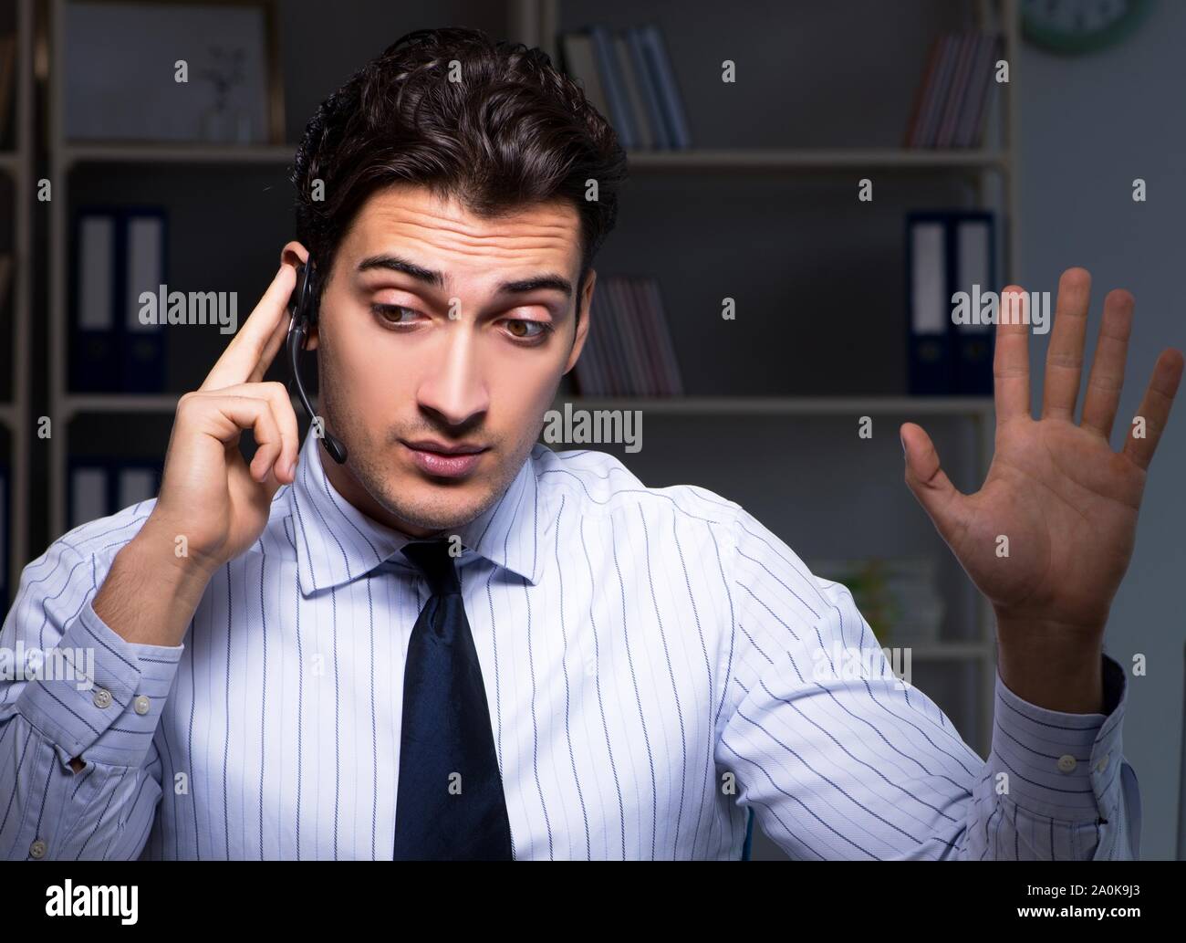 The call center operator talking to customer during night shift Stock