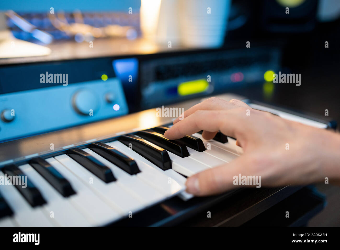 Hand of pianist pressing one of keys of piano keyboard while recording