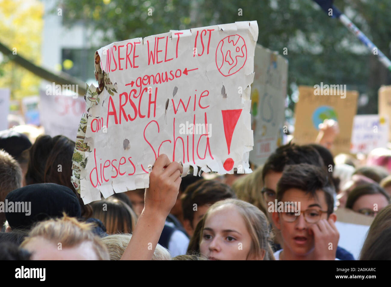 Demonstration during Global Climate Strike with damaged paper sign being held up saying 'Our world is as screwed as this sign' in German Stock Photo