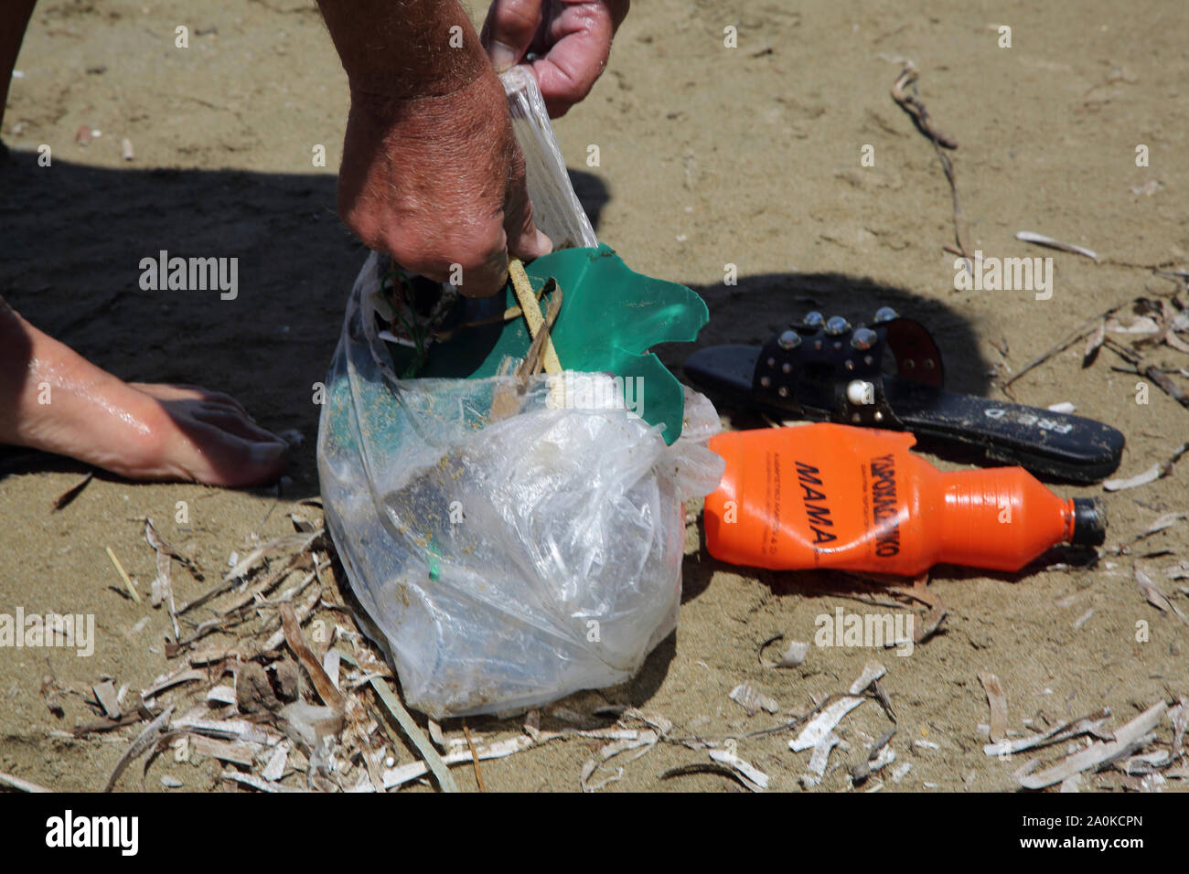 Vouliagmeni Attica Greece Vouliagmeni Beach Man Collecting Plastic Rubbish Stock Photo