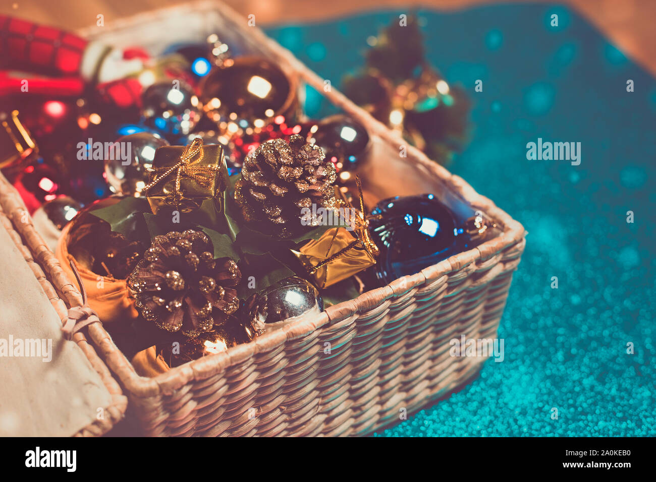wicker box on a shiny floor full of Christmas decorations Stock Photo