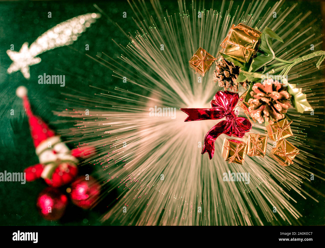 Christmas decorations and blurred santa on light rays in a green background Stock Photo