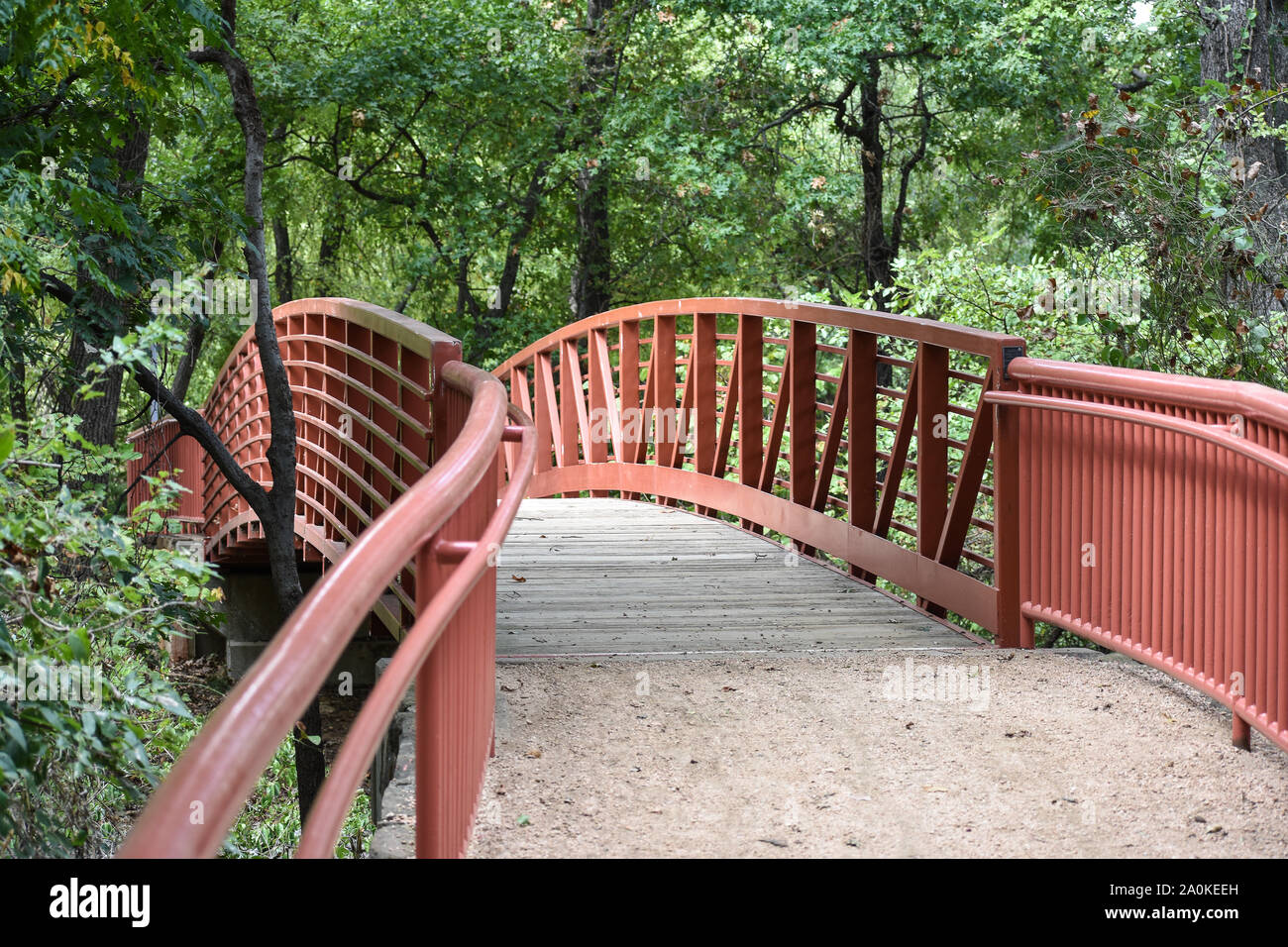 Pretty red bridge with tree canopy Stock Photo