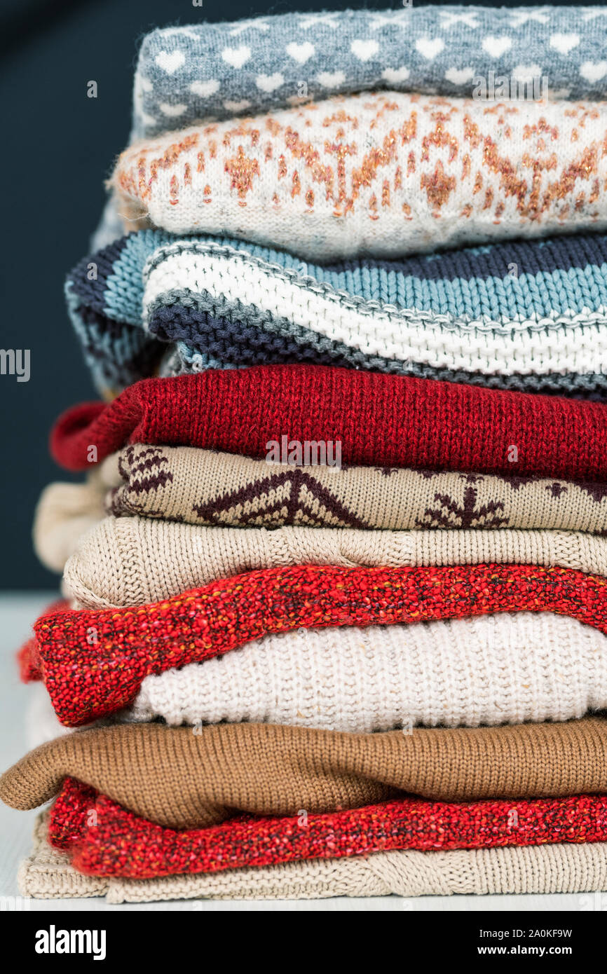 Stack of new woolen and cotton sweaters and jumpers prepared for cold days Stock Photo