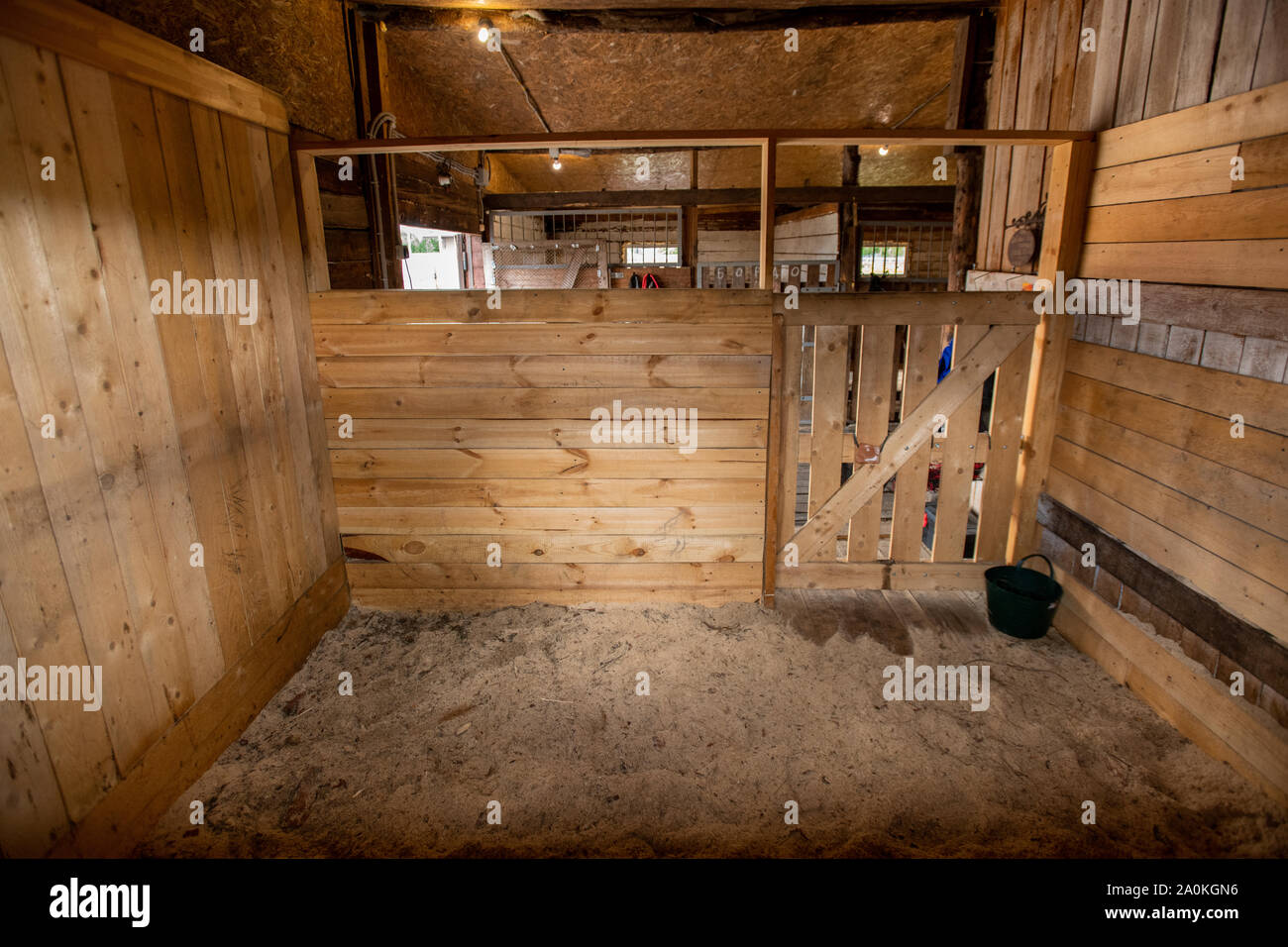 One of empty barns for racehorse surrounded by wooden walls and door Stock Photo