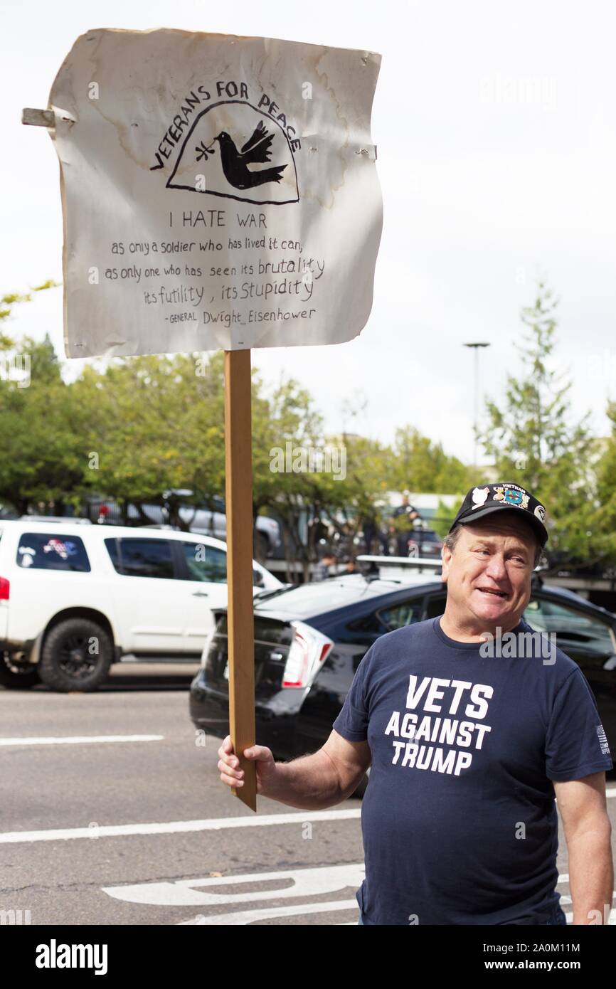 A man wearing a 'Vets Against Trump' t-shirt and carrying a sign, at the Climate Strike rally in Eugene, Oregon, USA. Stock Photo