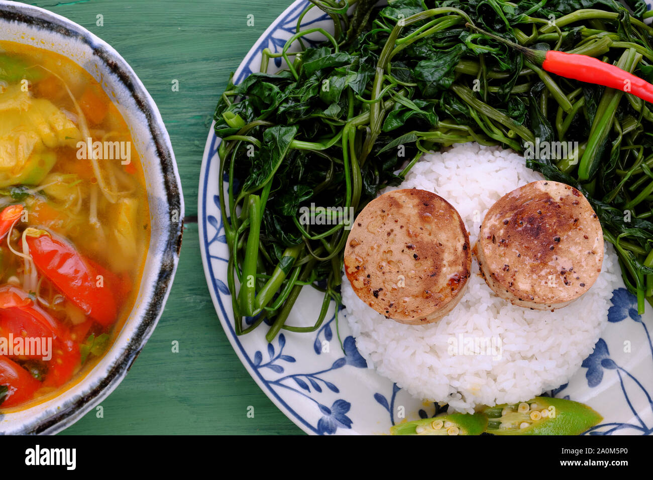 Plate of rice dish, boiled water morning glory, vegan sausage cook with